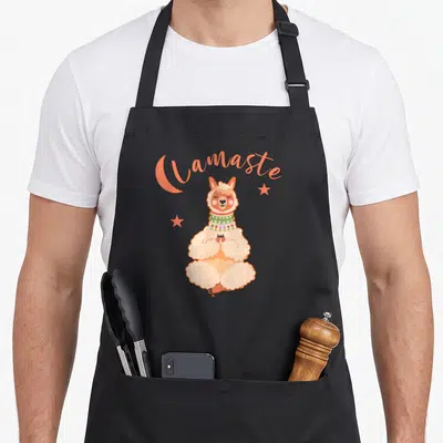 Tablier de cuisine noir avec un alpaga en taillesas sous le mot Lamaste et des étoiles oranges.