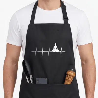 Tablier de cuisine noir avec silhouette blanche en posture de yoga au centre d'une ligne d'électrocardiogramme.