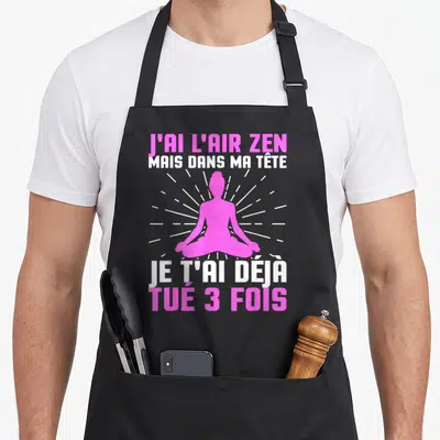 Tablier de cuisine noir avec silhouette rose en position de lotus et texte humoristique sur la méditation.