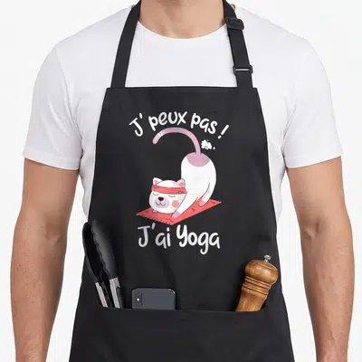 Tablier de cuisine noir avec un chat blanc en yoga sur tapis rose et texte J'peux pas j'ai Yoga