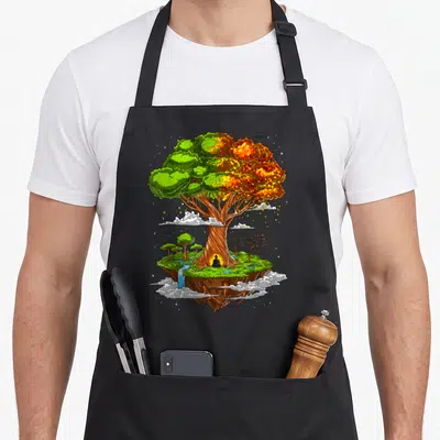 Tablier de cuisine noir avec illustration d'un Bouddha en méditation sous un grand arbre de vie coloré sur une île flottante.