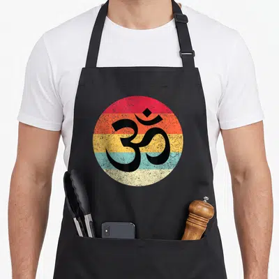 Tablier de cuisine noir avec un cercle coloré affichant le symbole Om en calligraphie noire au centre.