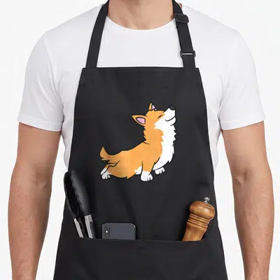 Tablier de cuisine noir avec illustration d'un corgi orange et blanc en position assise, la tête levée vers le haut avec les yeux fermés.
