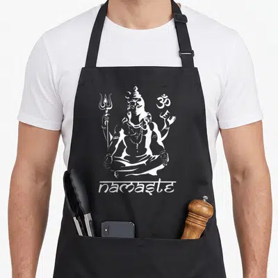 Tablier de cuisine noir avec illustration blanche d'une divinité assise en tailleur, un trident et le symbole om au-dessus du texte namaste.