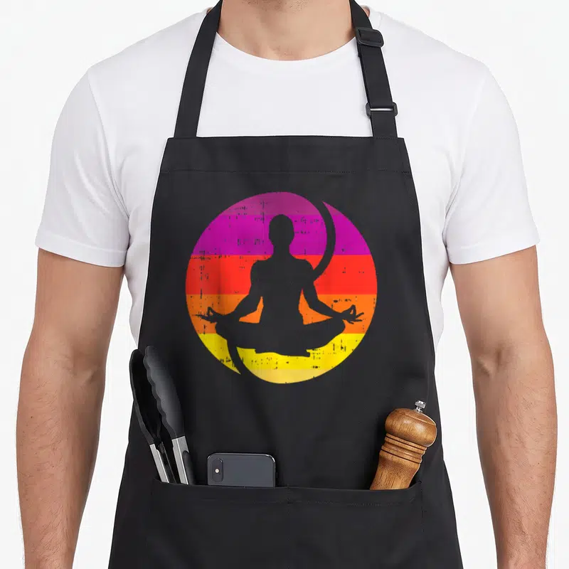 Tablier de cuisine noir avec silhouette de personne en posture de yoga sur fond circulaire aux couleurs vives dégradées.