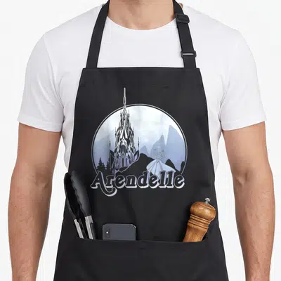 Tablier de cuisine noir avec illustration circulaire du château d'Arendelle et la silhouette d'Elsa en tenue de gala.