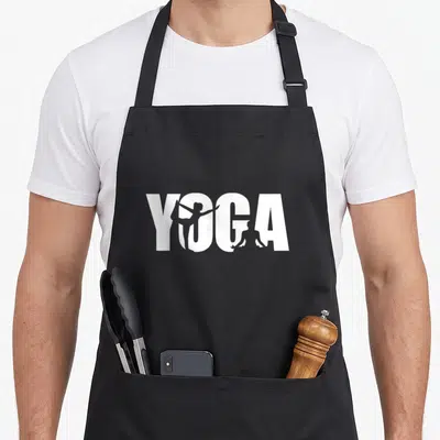 Tablier de cuisine noir avec le mot YOGA en blanc intégrant des silhouettes de personnes en postures d'étirement dans les lettres.
