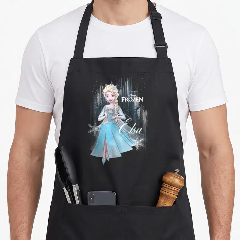 Tablier de cuisine noir avec illustration d'Elsa FROZEN aquarelle, flocons et texte Disney.