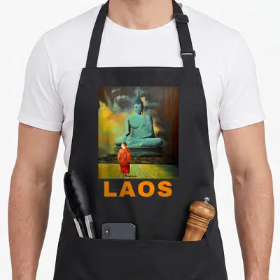 Tablier de cuisine noir avec une statue de Bouddha, un jeune moine en orange et le mot Laos en bas.
