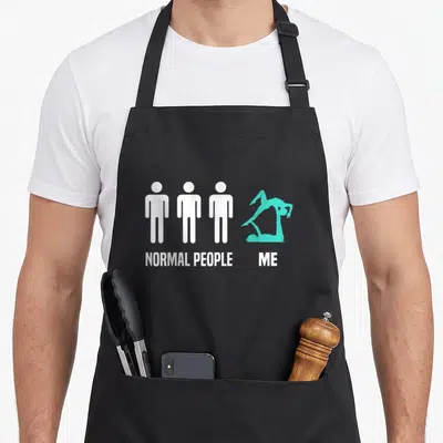 Tablier de cuisine noir avec trois silhouettes blanches et une figure d'acroyoga turquoise en position complexe.