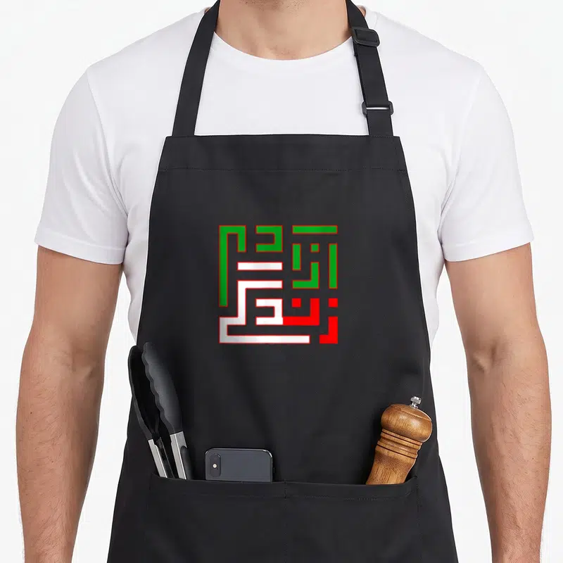 Tablier de cuisine noir avec motif calligraphique géométrique aux couleurs vert blanc et rouge représentant Zan Zendegi Azadi
